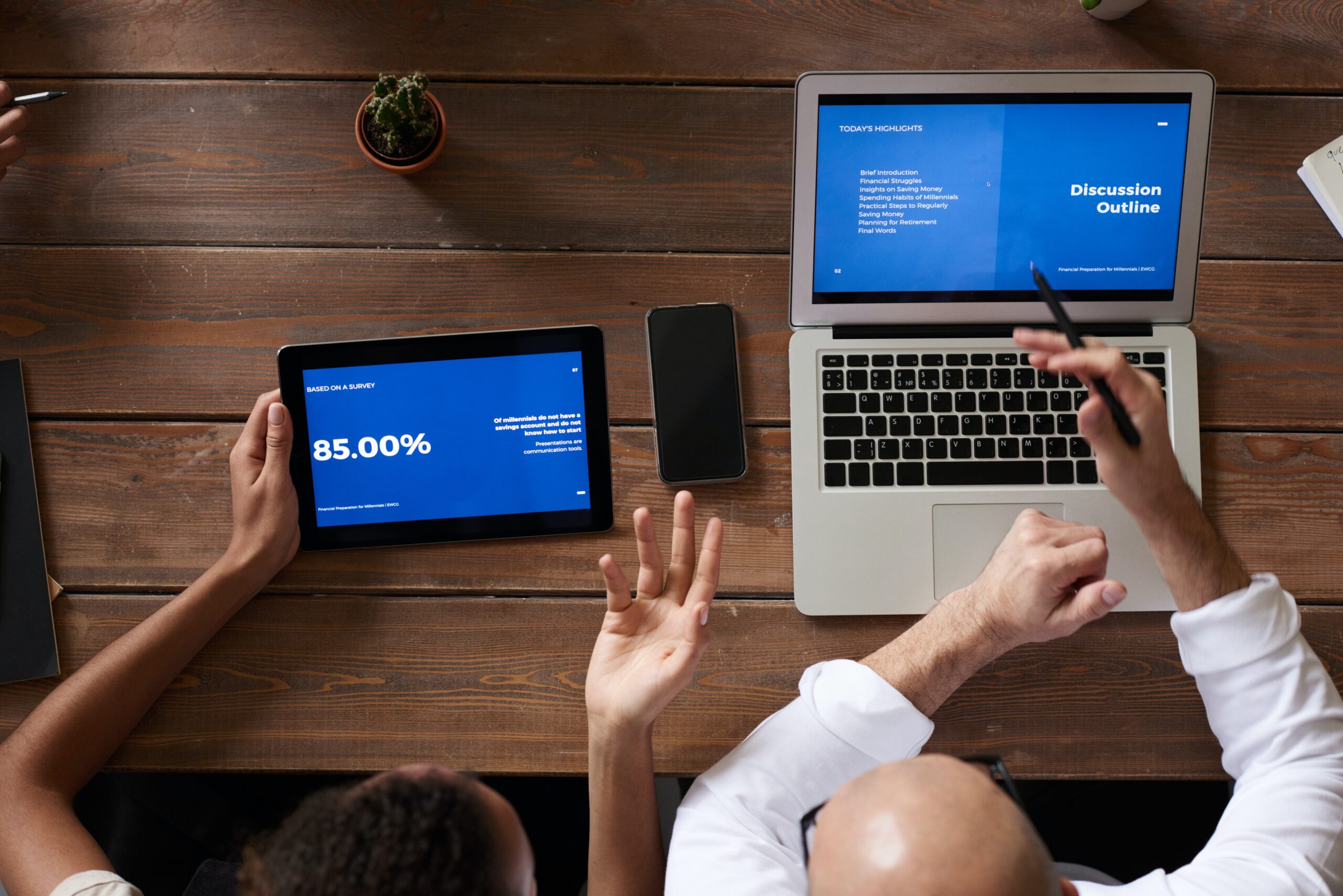 Two people reviewing investment figures on a laptop and tablet